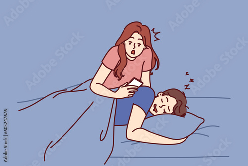 Jealous woman reads SMS in phone of boyfriend sleeping in bed and spies on husband checking incoming calls. Jealous wife does not trust partner due to relationship problems or regular cheating