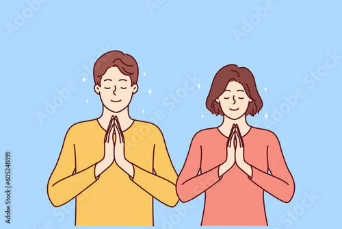 Praying man and woman fold palms in front of chests for joint prayer and religious ritual. Religious areni and girl with smile pray to god asking almighty for help in solving problems