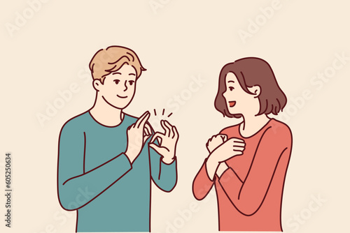 Deaf-mute man and woman are talking using sign language and demonstrating symbols with hands. Guy teaches girl sign language for concept of inclusiveness and socialization of people with disabilities