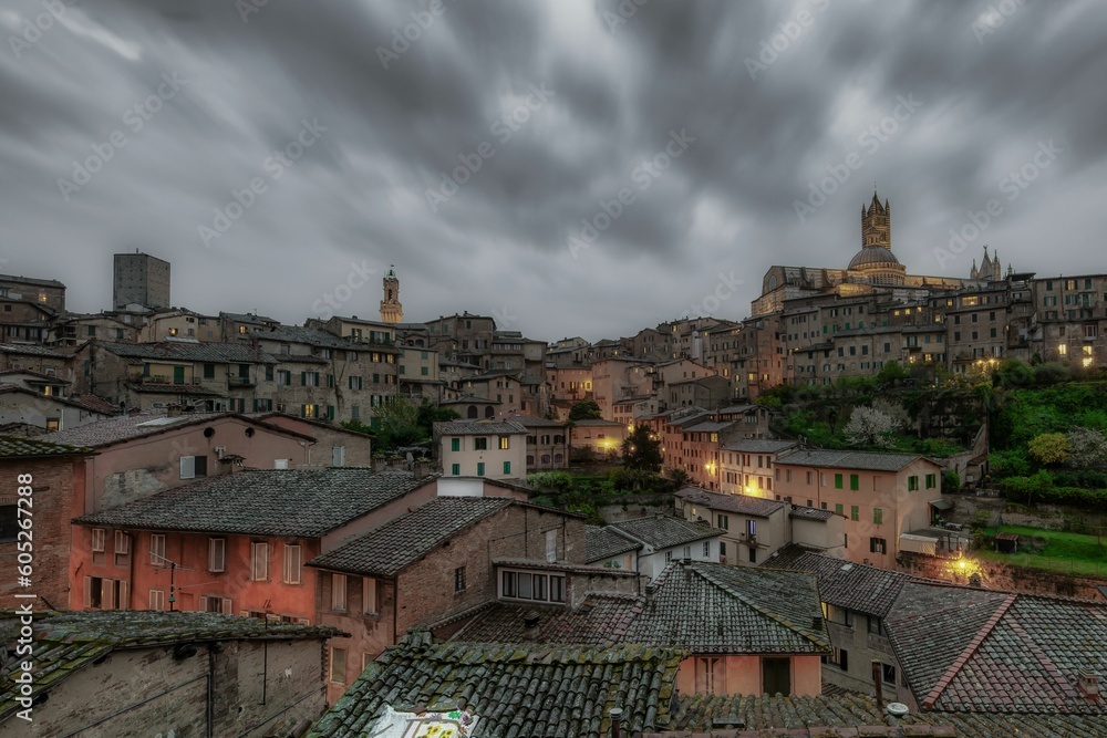 Beautiful shot of a stormy dark sky over a historic cityscape in Siena, Italy