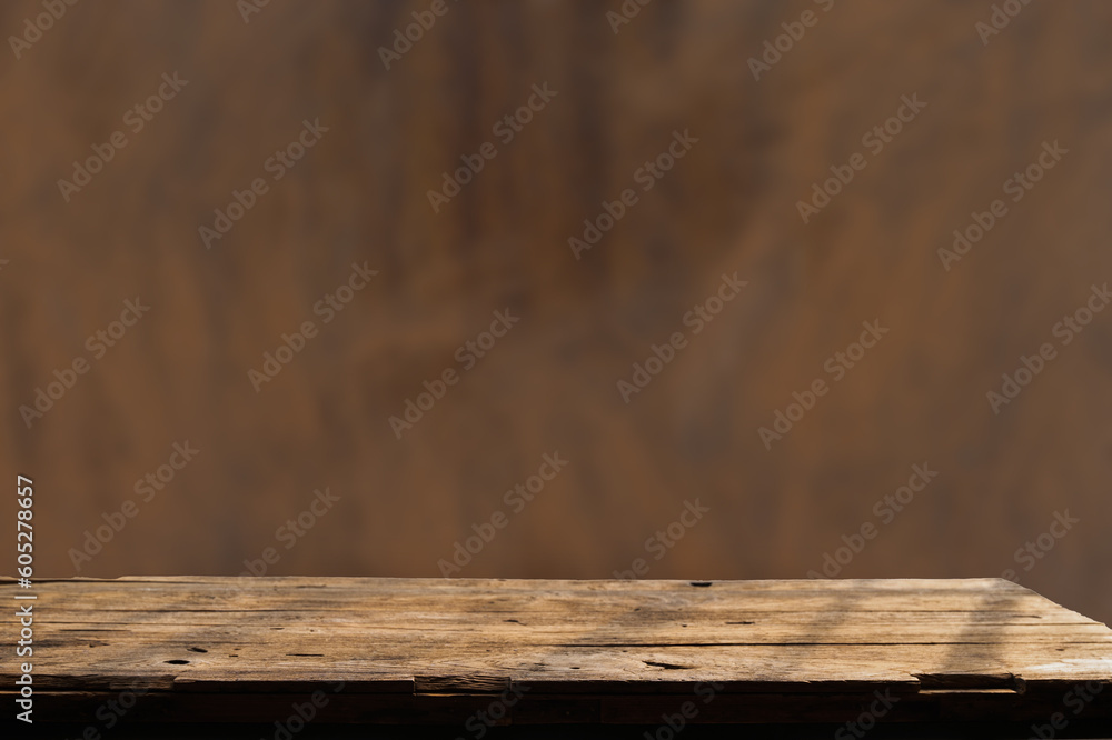 Empty wooden board on table top and blur inside over stucco wall blur background, mock up for display of goods.