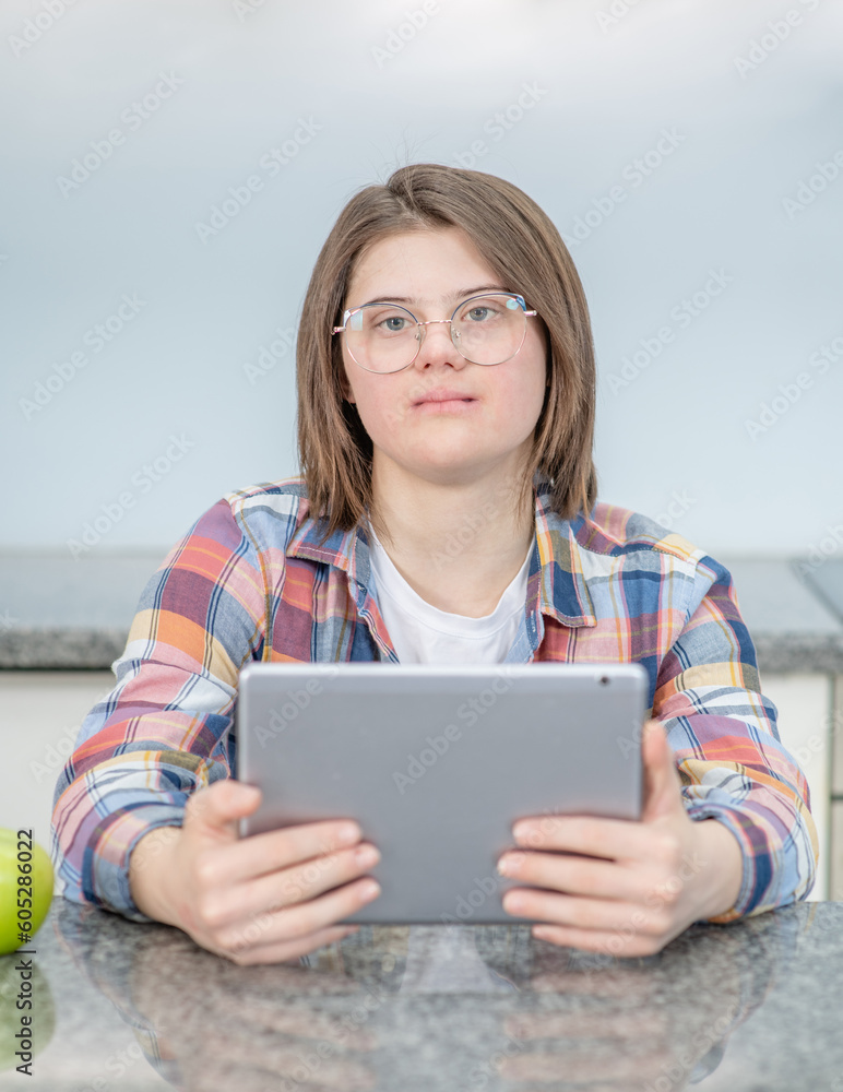 Young girl with Downs syndrome using tablet computer at home Young girl with Downs syndrome using tablet computer at home