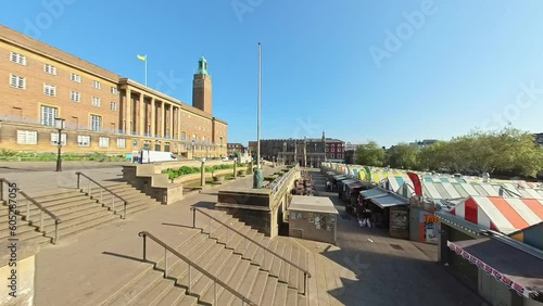Panning shot across the outdoor market and War Memorial Gardens in the city of Norwich. Captured on a bright and sunny morning