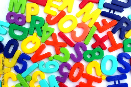  Many bright multi-colored letters lie on a white background.
