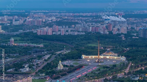 Aerial top view of Moscow city day to night timelapse after sunset. From the observation platform of the business center. Illuminated Victory Museum at park on Poklonnaya Hill. Traffic on Kutuzov ave