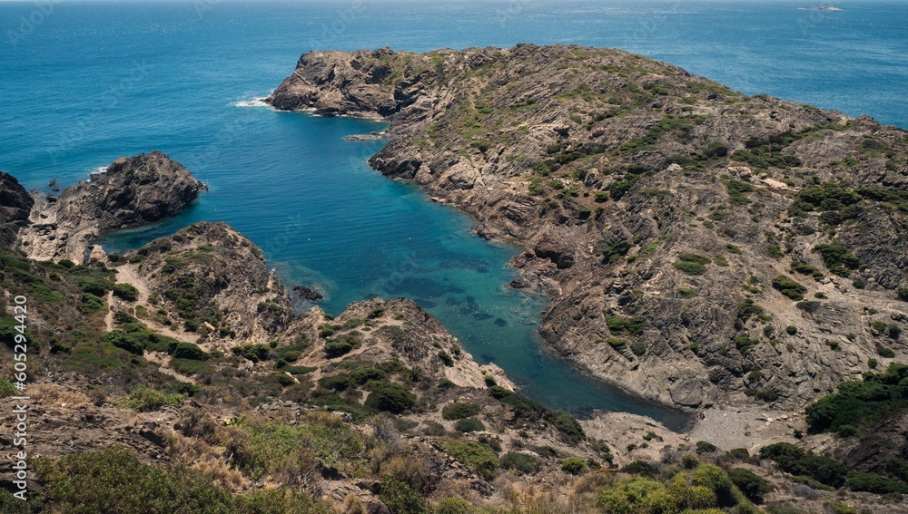 Aerial view of Fredosa cove rocky beach surrounded by emerald water in Cap de Creus