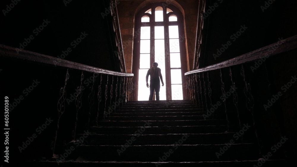 Silhouette of a man on top of the stairs