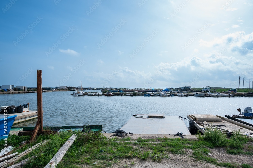 Seaport with a boats on water and a blue cloudy sky above