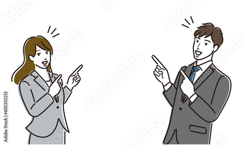 指をさして案内するスーツ姿の男女