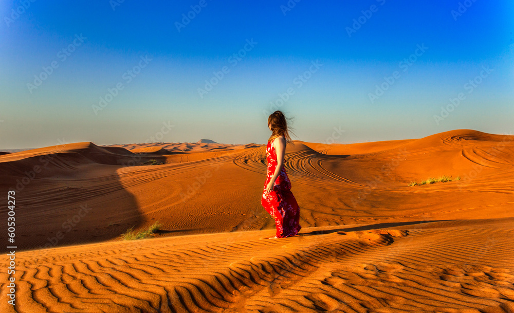 Woman in red walking on a dunes