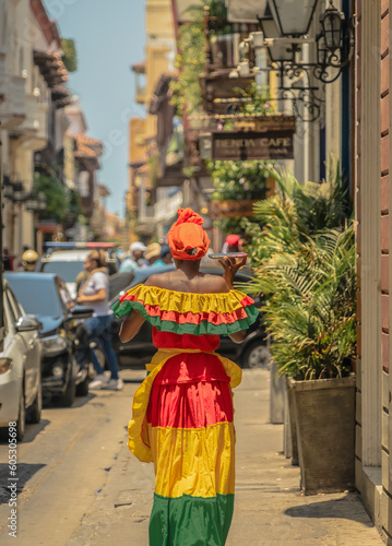 Colombian woman with typical dress of Cartagena de Indias walking through the streets. Travel photography. Trip to Colombia. Woman talking with her smartphone