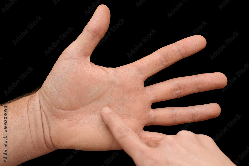 Chiromancer reading the lines on man's palm isolated on black background. The concept of palmistry and fortune-telling. Closeup.