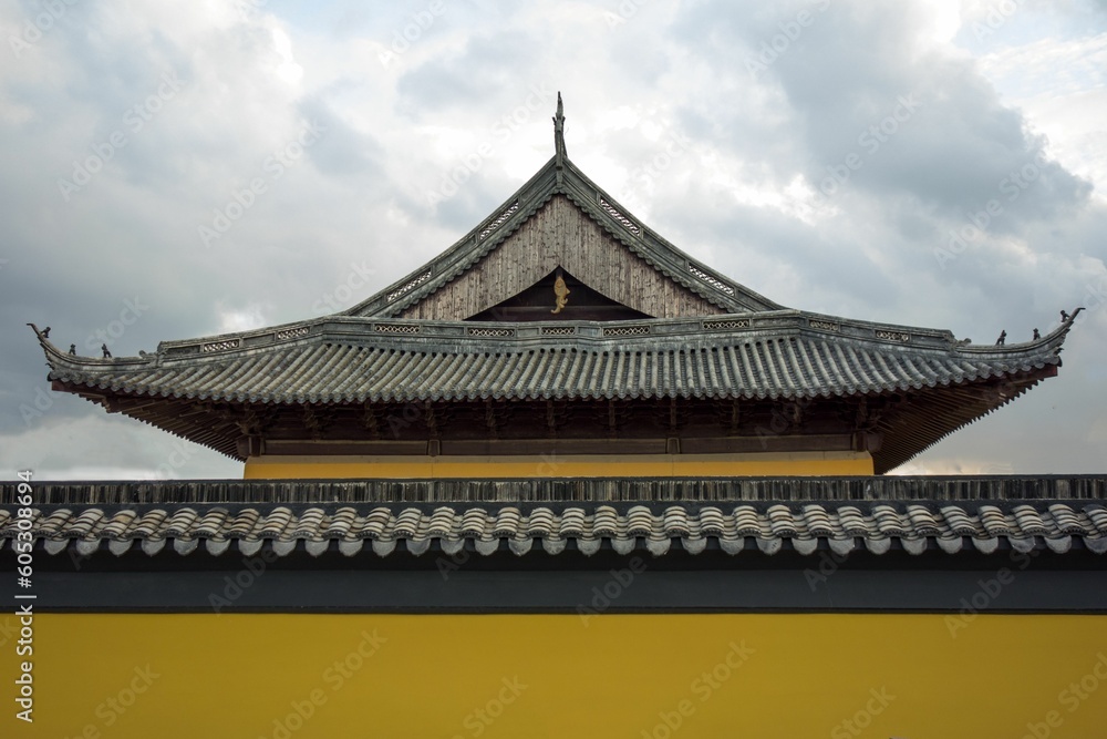 Traditional roof of an ancient Buddhist temple against a cloudy sky Traditional roof of an ancient Buddhist temple against a cloudy sky