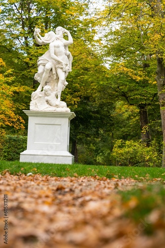 Vertical shot of a monument against autumnal trees in a park photo