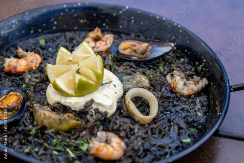 Closeup of Arros negre served on a pan in a restaurant