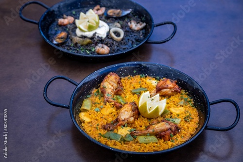 Closeup of two dishes of Paella and Arros negre served in a restaurant
