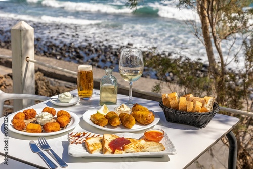 Close-up shot of fried fast food and French toast on a white table with a background of a sea