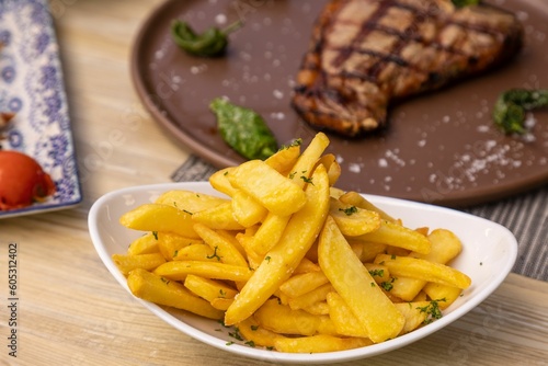 Close-up shot of french fries on a white plate served in a restaurant