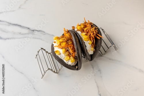 Steamed black gua bao buns with corn served on the marble table photo