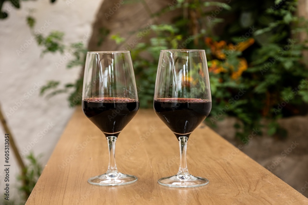 Closeup shot of two glasses of red wine on a wooden surface