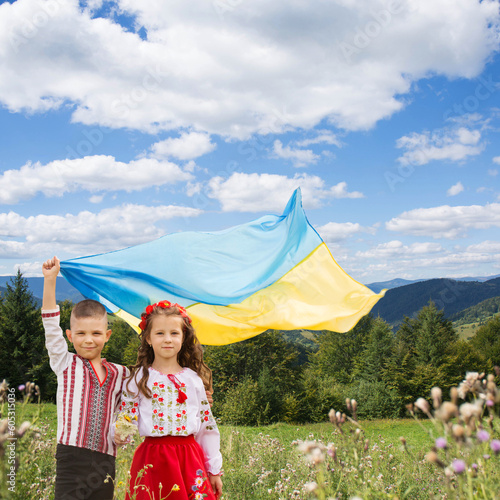 Ukrainian girl and boy holding a blue and yellow Ukrainian flag, a symbol of Ukrainian victory