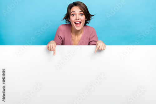 Photo of young crazy woman indicating fingers empty space banner crazy proposition product placement isolated on blue color background