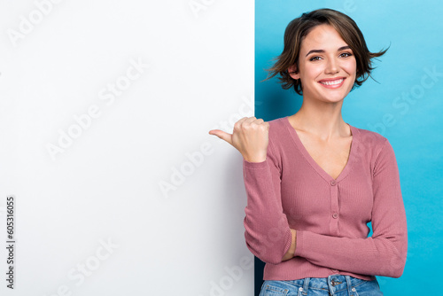 Photo of young attractive girlish woman promoter advertise point finger novelty billboard useful service isolated on blue color background photo