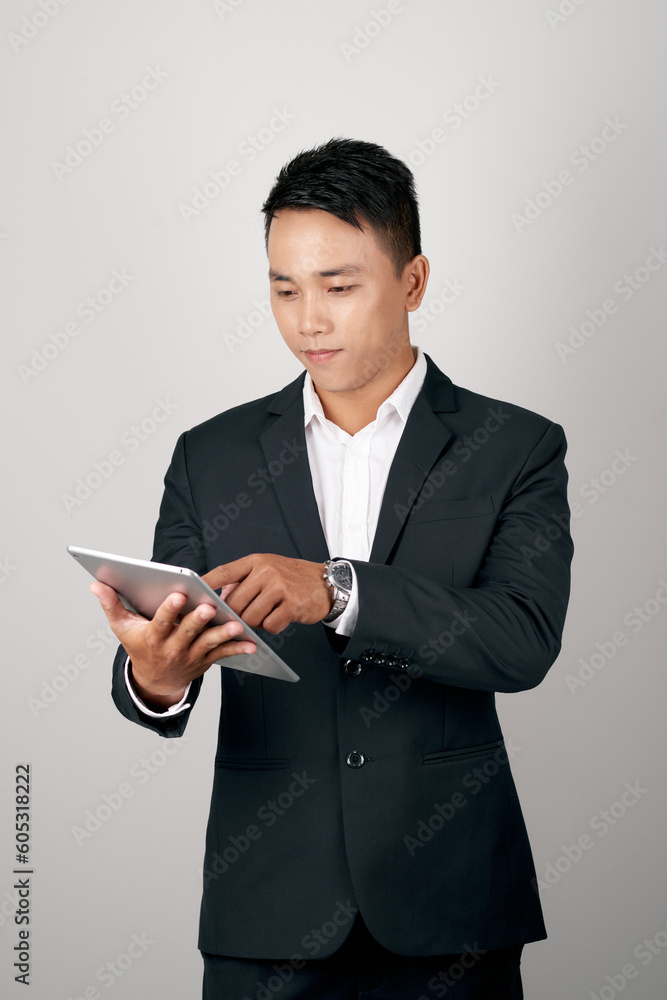 A handsome young businessman using a digital tablet on white background. A handsome young businessman using a digital tablet on white background.