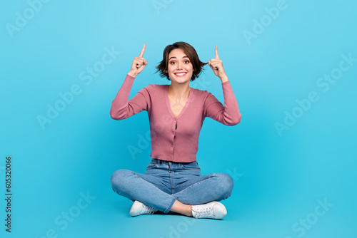 Valokuva Full length photo of cute positive person sit floor indicate fingers up empty sp