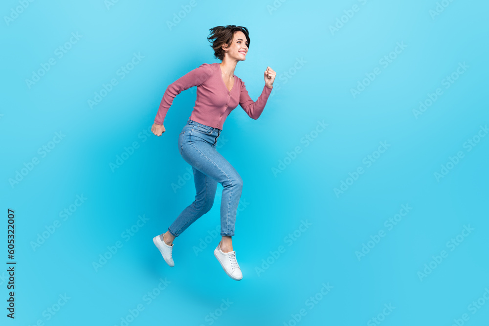 Full size profile photo of crazy active girl jumping run empty space ad isolated on blue color background Full size profile photo of crazy active girl jumping run empty space ad isolated on blue color background