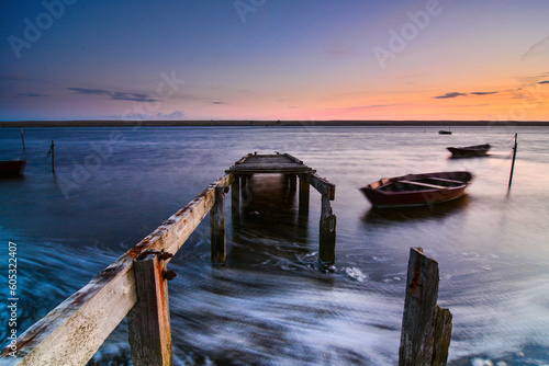 Sea scene with jetty  boats at sunset.