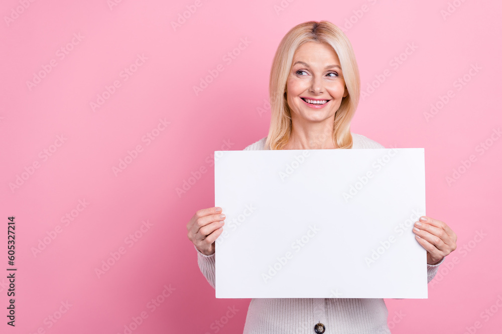 Photo of cheerful lovely lady arms hold paper list look empty space isolated on pink color background Photo of cheerful lovely lady arms hold paper list look empty space isolated on pink color background
