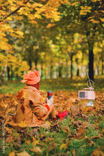 Redhaired young hipster woman watching retro TV in the park in the fall. Recreation Concept