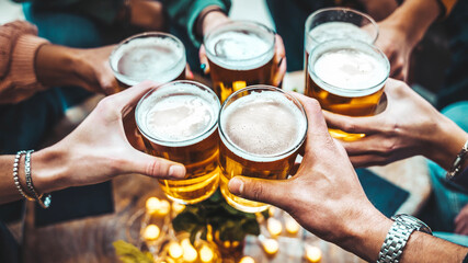 Group of people drinking beer at brewery pub restaurant - Happy friends enjoying happy hour sitting at bar table - Closeup image of brew glasses - Food and beverage lifestyle concept