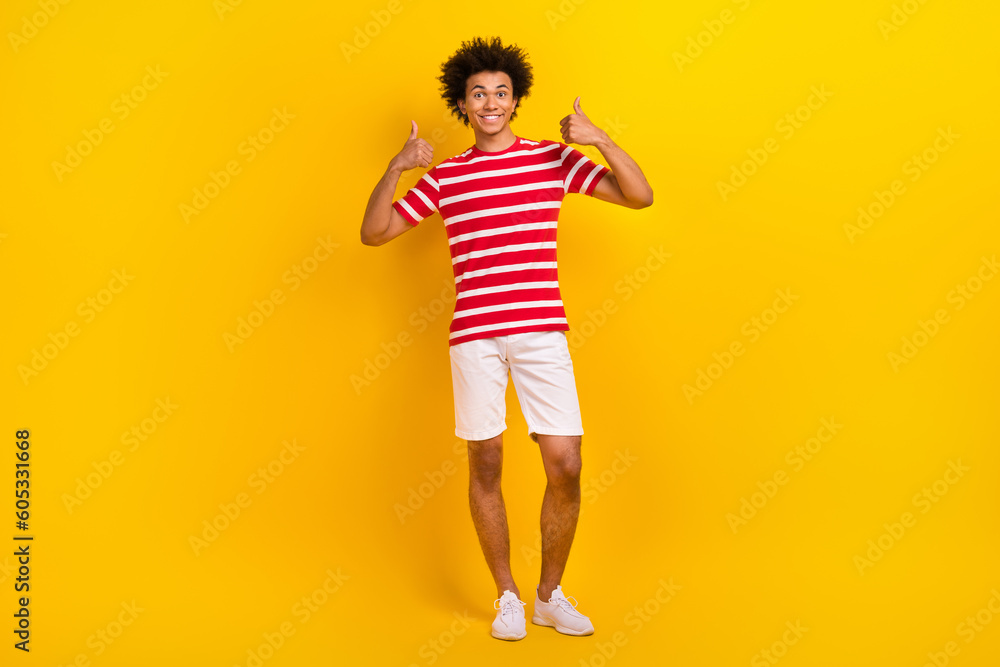 Full body photo of young hipster guy raise hands arms thumbs up wear summer shirt pants isolated yellow color background Full body photo of young hipster guy raise hands arms thumbs up wear summer shirt pants isolated yellow color background
