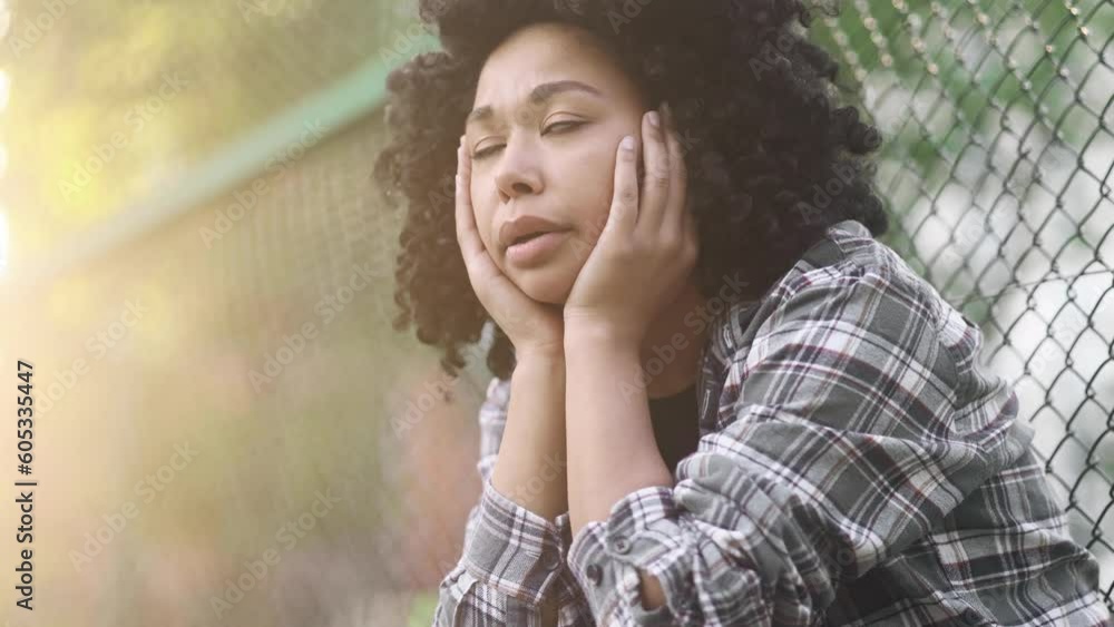 Portrait of sad young African American woman suffering from depression anxiety loneliness or mental health problem outdoors Curly upset feeling stress and pressure at green park Portrait of sad young African American woman suffering from depression anxiety loneliness or mental health problem outdoors Curly upset feeling stress and pressure at green park