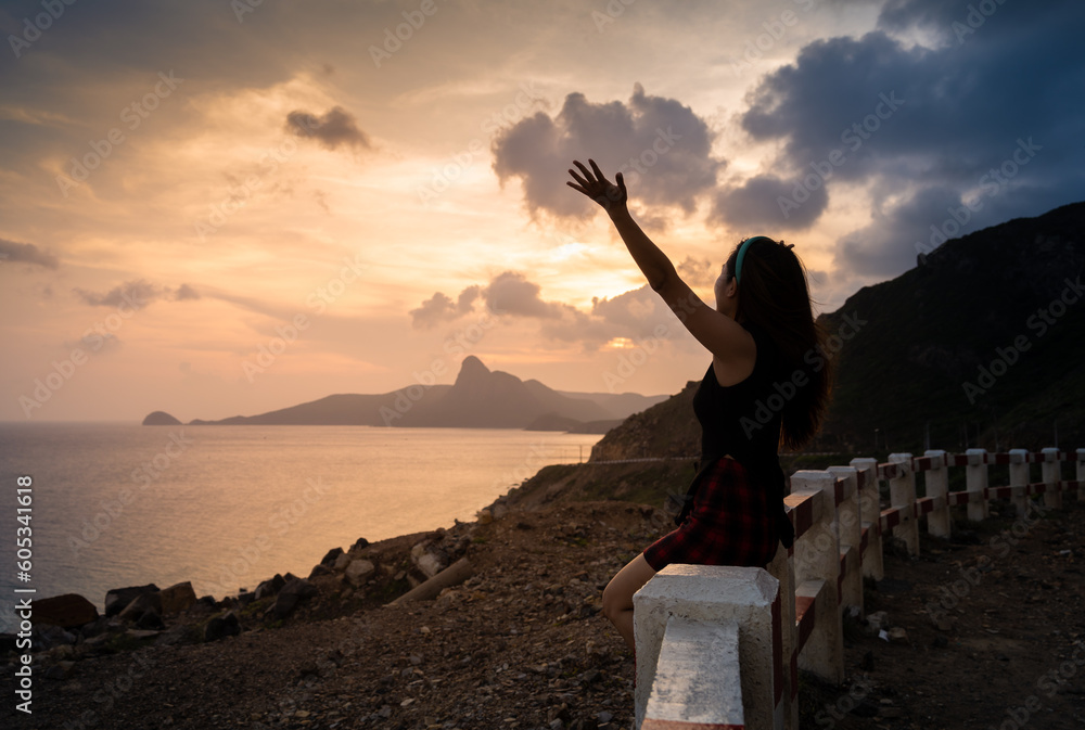Traveler woman relaxing on fence above Nhat beach, Con Dao island