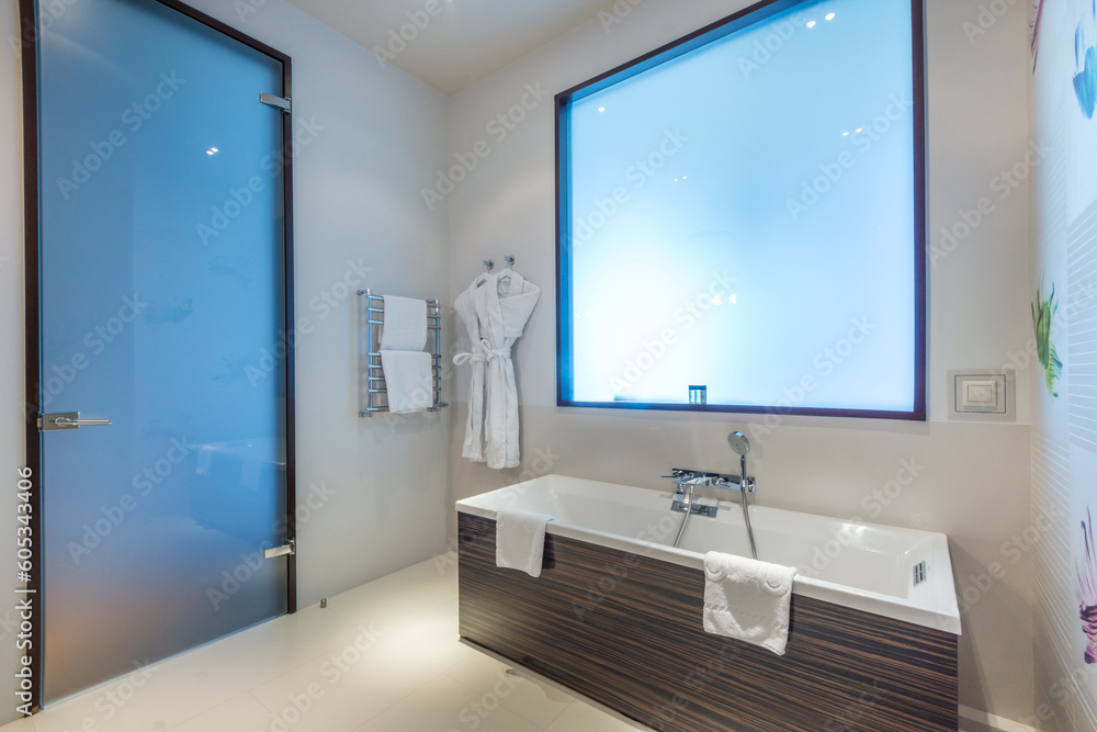 Φωτογραφία Stylish design of the bathroom in the hotel, with a frosted glass door and a false window