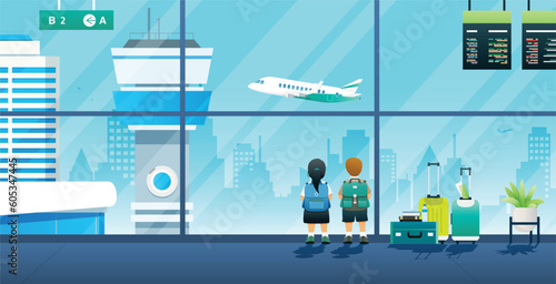 Boys and girls are watching planes while waiting for a flight in the airport.

