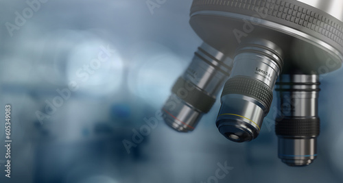 Detail of microscope lens in blurred lab background.