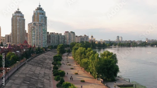 Aerial drone view of city river embankment. Urban cityscape with walking people. photo