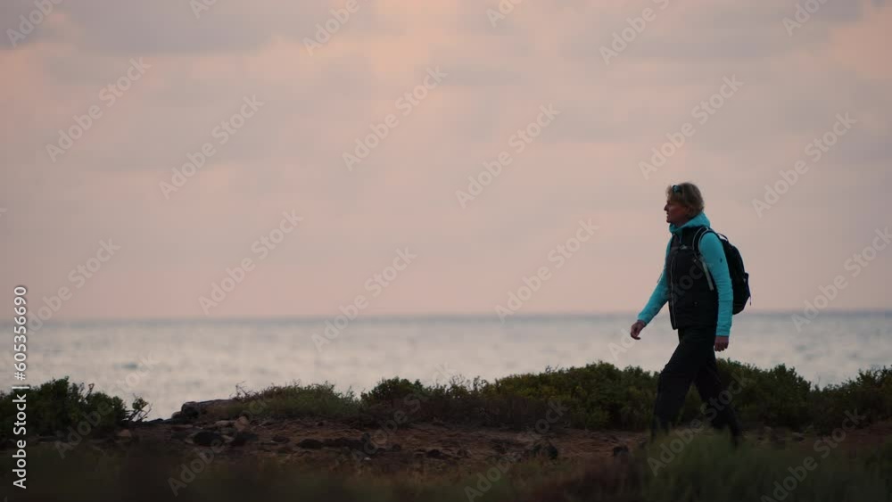 Solo female hiker walking desert ocean coastal path Solo female hiker walking desert ocean coastal path