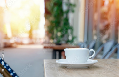 Fototapeta Naklejka Na Ścianę i Meble -  white single cup of coffee in a street cafe