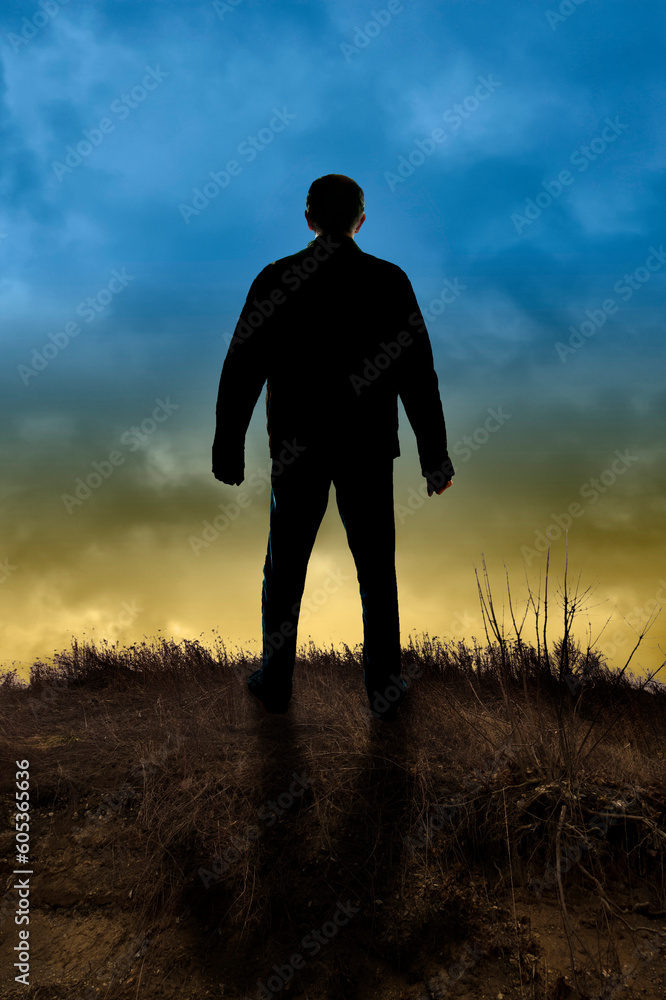 man silhouette standing on a hill