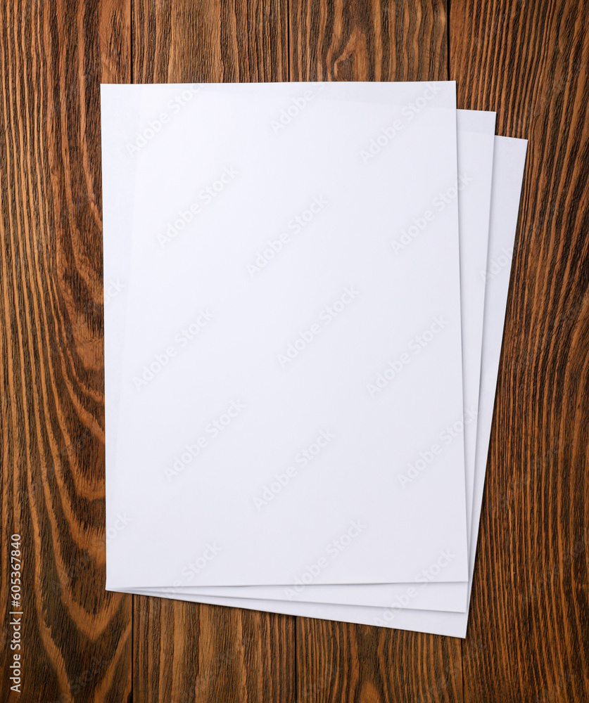 A4 paper sheets on a wooden background. A4 paper sheets on a wooden background.