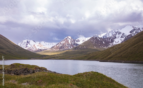 High mountains of the Tian Shan Range with Kol Ukok lake in the foreground in Kyrgyzstan