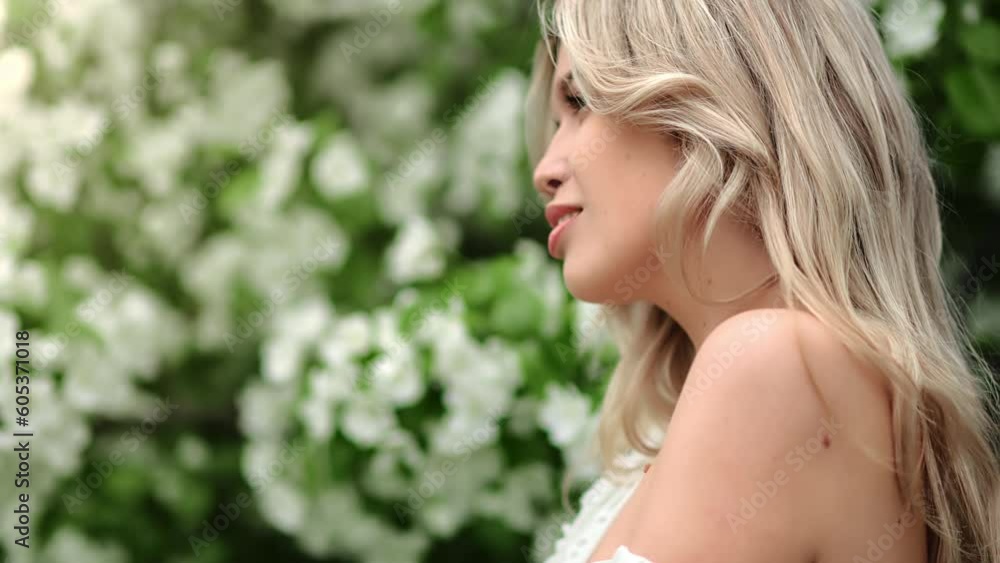 Gentle young blonde woman posing at summer spring with white blossom flower tree park closeup Gentle young blonde woman posing at summer spring with white blossom flower tree park closeup