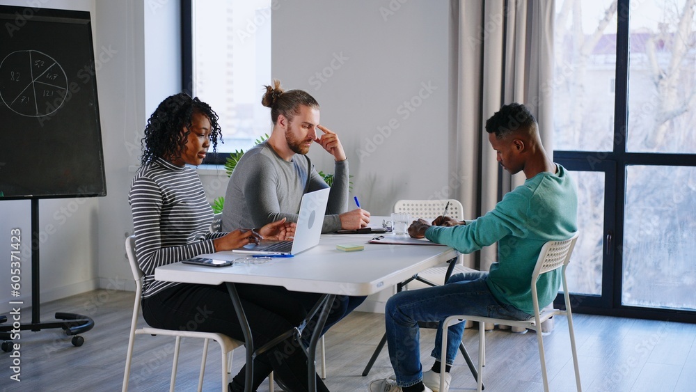 Office workers creative team are talking then doing high-five hand gesture working together around table. Office workers creative team are talking then doing high-five hand gesture working together around table.