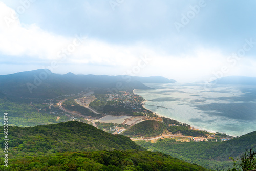 a peaceful Con Dao island, Vietnam, view from Thanh Gia mountain. Coastal view with waves, coastline, clear sky and road, blue sea and mountain.