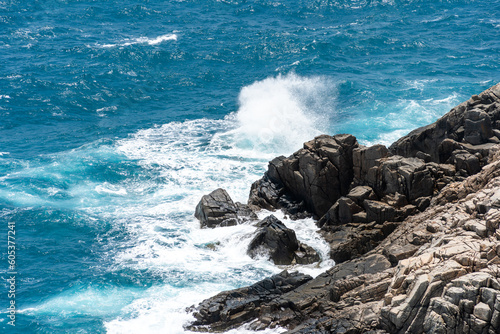 Fototapeta Naklejka Na Ścianę i Meble -  waves hit the rock at beach, sea water splash up to the sky with sun. A peaceful Con Dao island, Vietnam is a Vietnamese island heaven